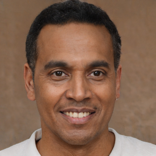 Joyful latino adult male with short  black hair and brown eyes