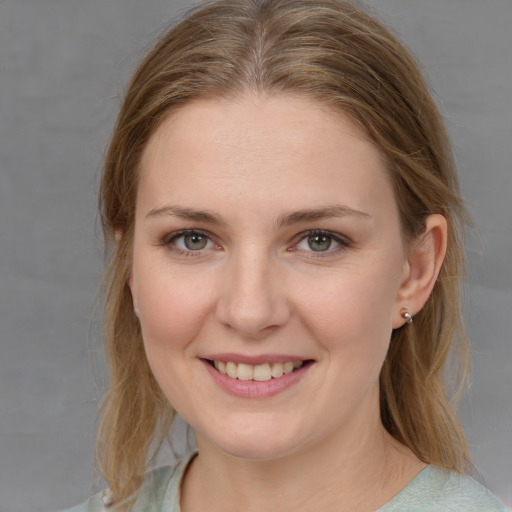 Joyful white young-adult female with medium  brown hair and grey eyes