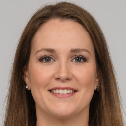 Joyful white adult female with long  brown hair and grey eyes