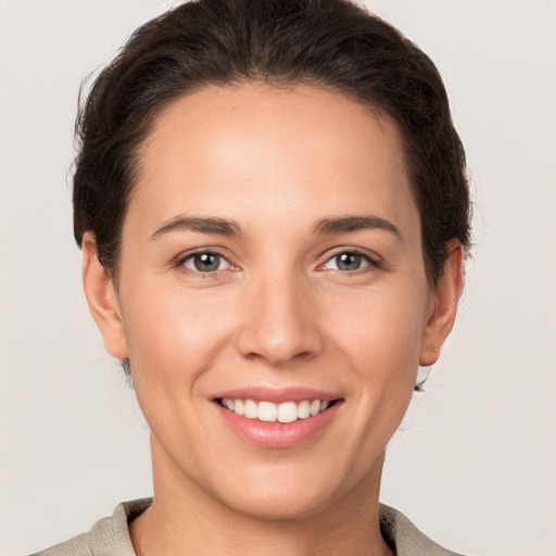 Joyful white young-adult female with short  brown hair and grey eyes