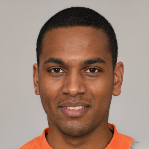 Joyful black young-adult male with short  black hair and brown eyes