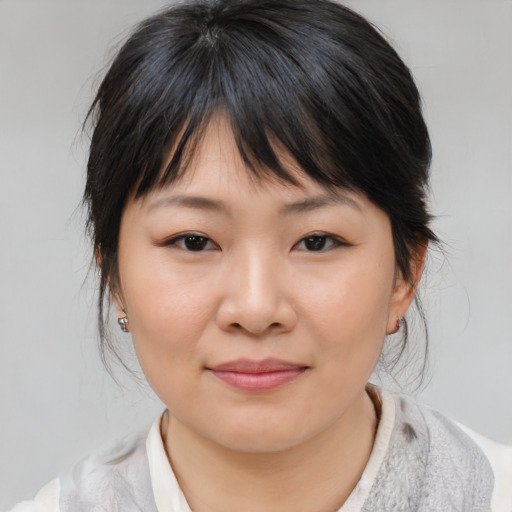 Joyful asian young-adult female with medium  brown hair and brown eyes