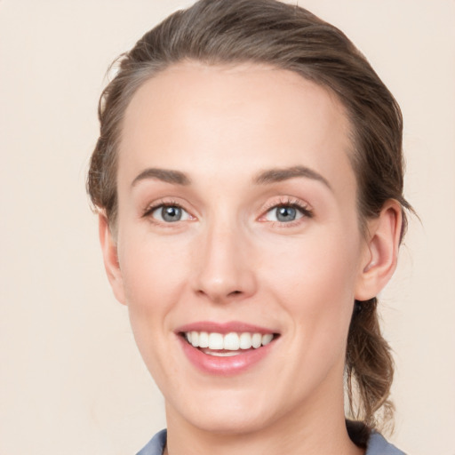 Joyful white young-adult female with medium  brown hair and blue eyes