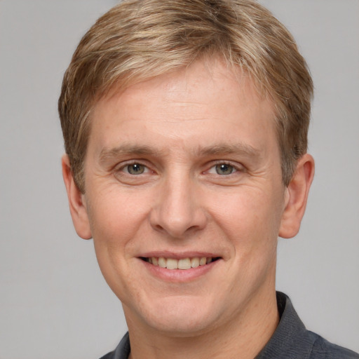 Joyful white adult male with short  brown hair and grey eyes