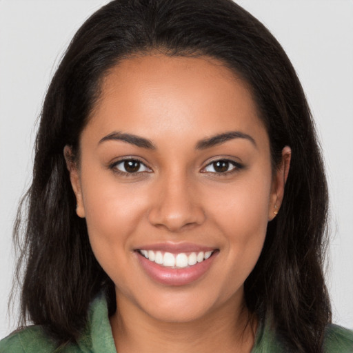 Joyful latino young-adult female with long  brown hair and brown eyes