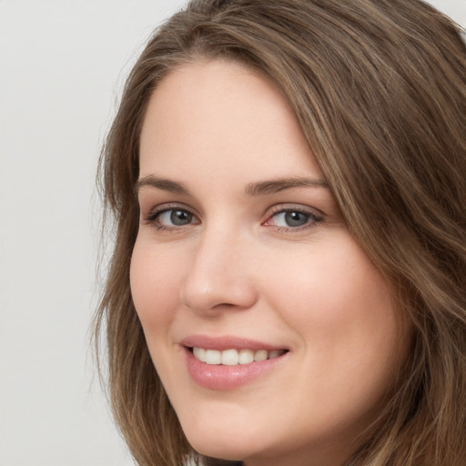 Joyful white young-adult female with long  brown hair and green eyes