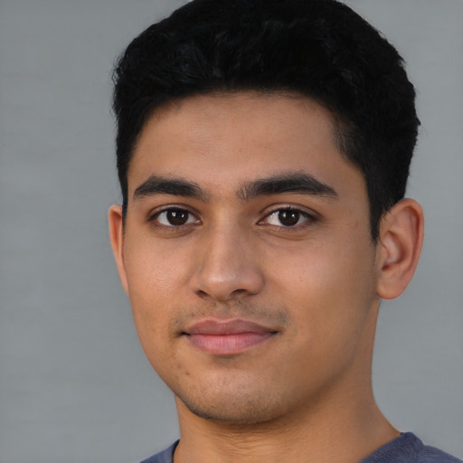 Joyful latino young-adult male with short  black hair and brown eyes