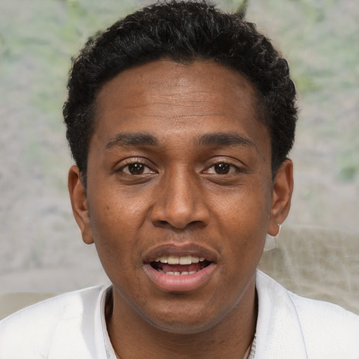 Joyful black young-adult male with short  black hair and brown eyes