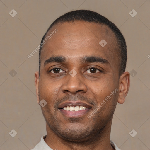 Joyful black young-adult male with short  black hair and brown eyes