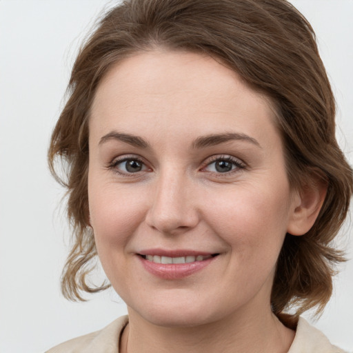 Joyful white young-adult female with medium  brown hair and green eyes