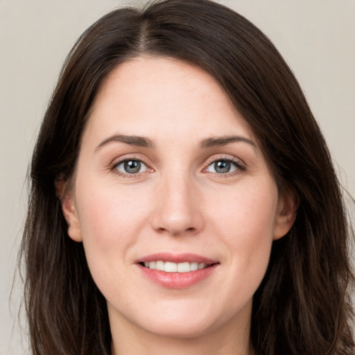 Joyful white young-adult female with long  brown hair and grey eyes