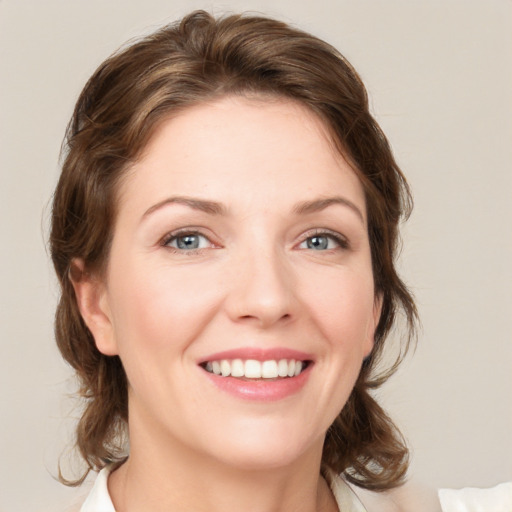 Joyful white young-adult female with medium  brown hair and green eyes