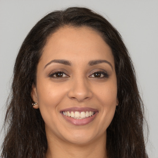 Joyful latino young-adult female with long  brown hair and brown eyes