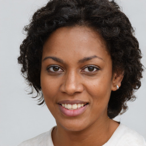 Joyful black young-adult female with medium  brown hair and brown eyes