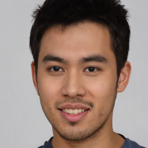 Joyful asian young-adult male with short  brown hair and brown eyes