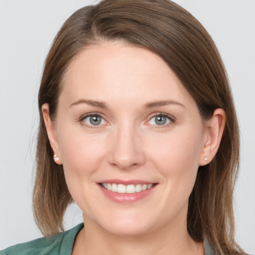 Joyful white young-adult female with long  brown hair and grey eyes