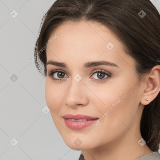 Joyful white young-adult female with long  brown hair and brown eyes