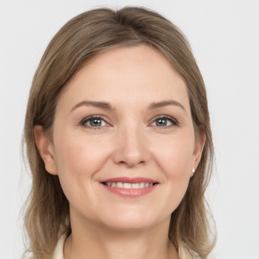 Joyful white young-adult female with medium  brown hair and grey eyes