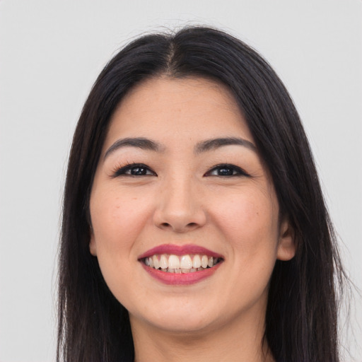 Joyful asian young-adult female with long  black hair and brown eyes