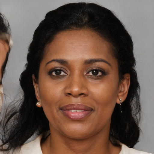 Joyful black adult female with medium  black hair and brown eyes