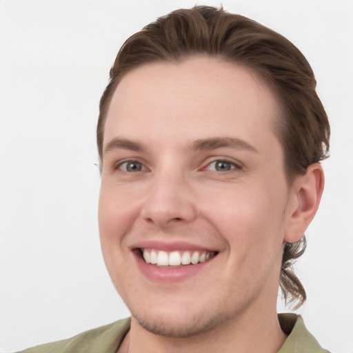 Joyful white young-adult male with short  brown hair and grey eyes