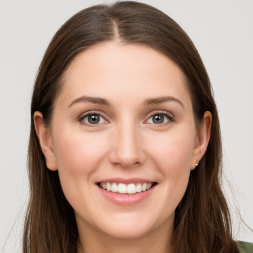 Joyful white young-adult female with long  brown hair and grey eyes