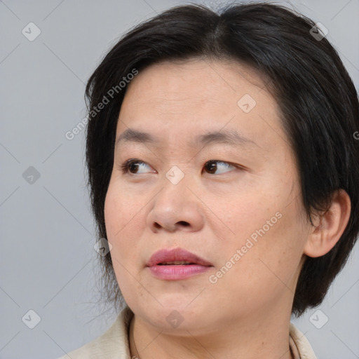 Joyful asian adult female with medium  brown hair and brown eyes