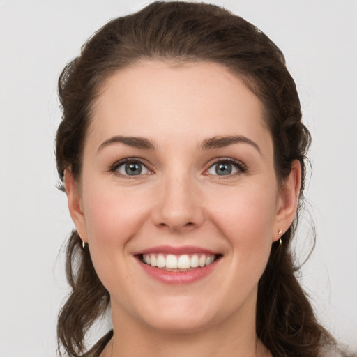 Joyful white young-adult female with long  brown hair and grey eyes