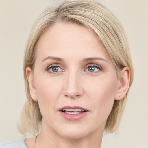 Joyful white adult female with medium  brown hair and blue eyes