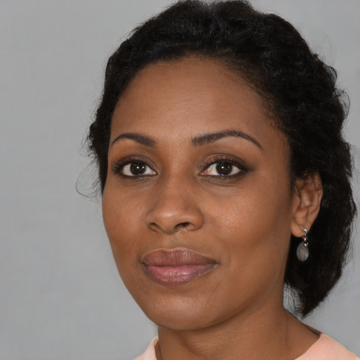 Joyful black young-adult female with medium  black hair and brown eyes