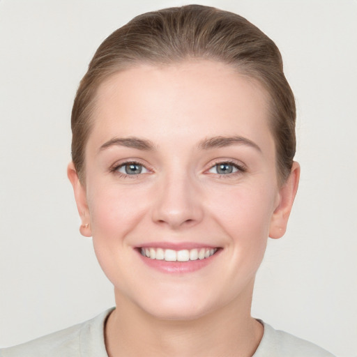 Joyful white young-adult female with short  brown hair and grey eyes