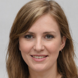 Joyful white young-adult female with long  brown hair and grey eyes