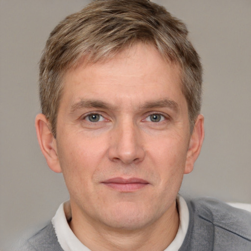 Joyful white adult male with short  brown hair and grey eyes