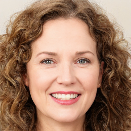 Joyful white young-adult female with long  brown hair and green eyes