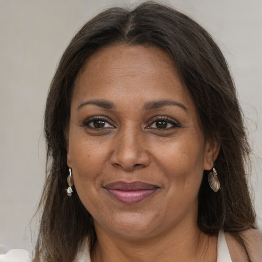 Joyful black adult female with long  brown hair and brown eyes