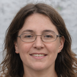 Joyful white adult female with long  brown hair and grey eyes