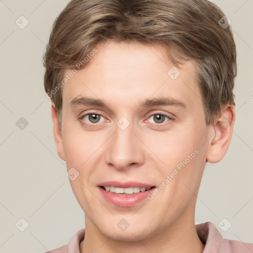 Joyful white young-adult male with short  brown hair and grey eyes