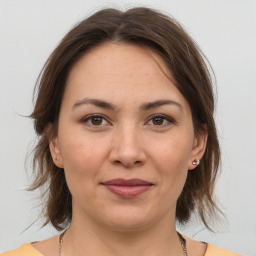 Joyful white young-adult female with medium  brown hair and grey eyes