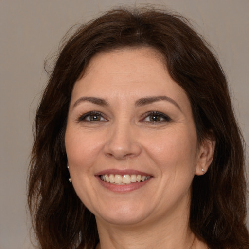 Joyful white adult female with long  brown hair and brown eyes