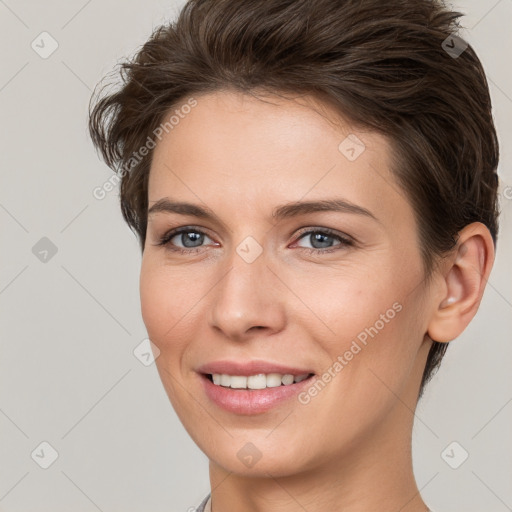 Joyful white young-adult female with short  brown hair and grey eyes