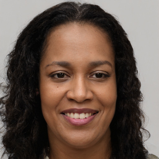 Joyful black young-adult female with long  brown hair and brown eyes