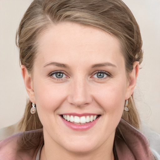 Joyful white young-adult female with medium  brown hair and blue eyes