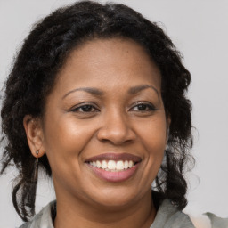 Joyful black adult female with medium  brown hair and brown eyes