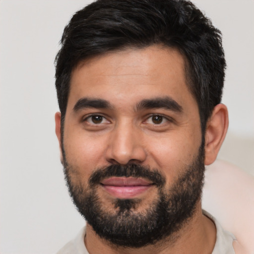 Joyful latino young-adult male with short  black hair and brown eyes