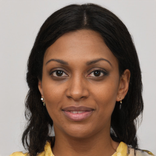 Joyful black young-adult female with medium  brown hair and brown eyes