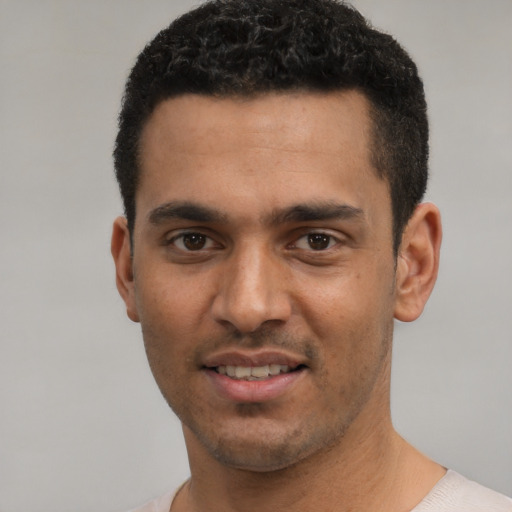 Joyful white young-adult male with short  black hair and brown eyes