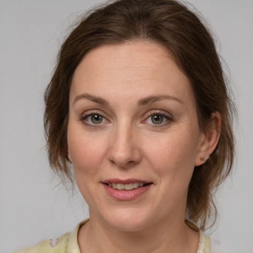 Joyful white young-adult female with medium  brown hair and green eyes