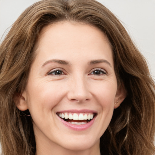 Joyful white young-adult female with long  brown hair and green eyes