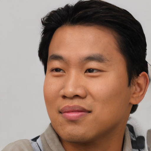 Joyful asian young-adult male with short  black hair and brown eyes