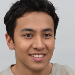 Joyful latino young-adult male with short  brown hair and brown eyes